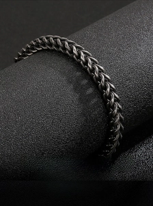 Macro detail of men's stainless steel woven chain bracelet with vintage punk finish
