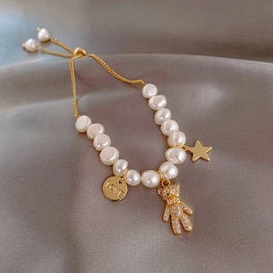 Gold plated baroque freshwater pearl bracelet featuring a micro-set bear and love pendant