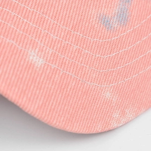 Detail der rosa Batik-Sonnenblende mit weißen Nähten und gewaschener Baumwolltextur