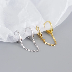 Macro shot of minimalist S925 sterling silver chain link earrings in gold and silver