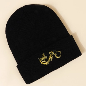 Close-up of golden dragon embroidery on black knit beanie with windproof texture