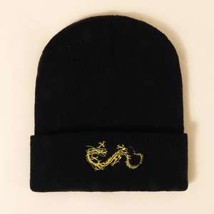 Detailed view of intricate gold dragon embroidery on a black knitted winter beanie cap