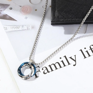 Detail of interlocking silver and blue steel rings pendant on a square box chain link