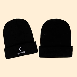 Detail of black knit beanie with white embroidered you decide text and smiley face
