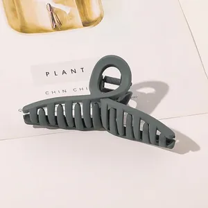 Detail shot of large matte charcoal grey hair claw clip showing a cross arch design