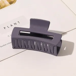 Detailed side view of a large dark grey matte rectangle hair claw clip for bun hairstyles