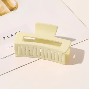 Detail of large matte cream hair claw clip with square hollow design for updo styling