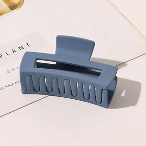 Detail of matte gray-blue large hollow square hair claw clip on minimalist background
