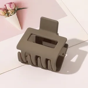 Detail of large matte coffee shark hair claw clip for thick hair in minimalist design