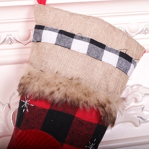 Detail of red and black buffalo plaid Christmas stocking with faux fur trim and snowflake