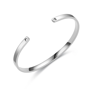Macro view of polished silver C-shaped stainless steel bracelet with open end details