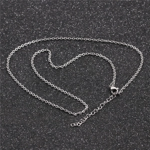 Close-up of silver cable chain with lobster clasp and adjustable extension on black background