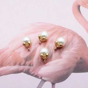 Elegant gold leaf pearl pendant accessories for DIY jewelry making on pink background