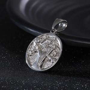 Macro detail of silver Tree of Life pendant in polished stainless steel for men