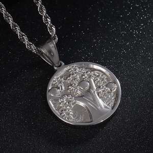 Macro shot of polished silver stainless steel Tree of Life embossed pendant necklace