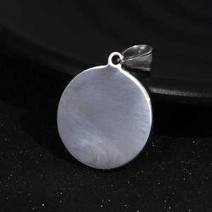Close-up of a round silver stainless steel pendant featuring a brushed metal texture
