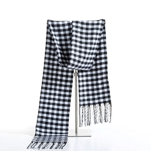 Classic black and white checkered scarf with elegant fringes on a T-bar display stand