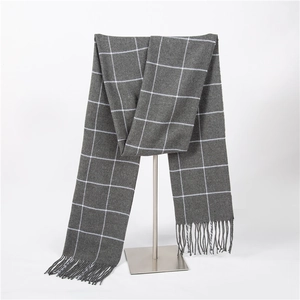 Detail of grey windowpane check scarf with elegant fringes hanging on a display stand