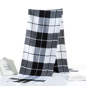 Detailed view of black and white checkered scarf with soft fringe texture and drape