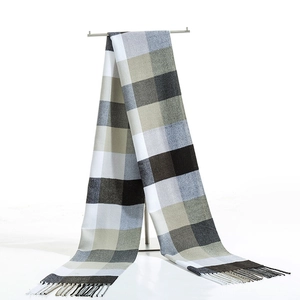 Detailed shot of classic black and white plaid scarf with soft fringe tassels on a display