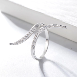 Elegant silver s-shaped wave ring with micro-pave cubic zirconia on a white stone background