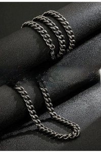 Detail of vintage gunmetal stainless steel NK chain necklace with polished curb link texture