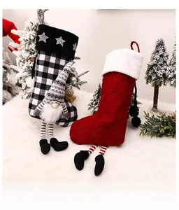 Détail de chaussettes de Noël festives avec un gnome rouge et un motif à carreaux noir et blanc