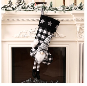 Détail de chaussette de Noël à carreaux noir et blanc avec gnome suspendue à la cheminée