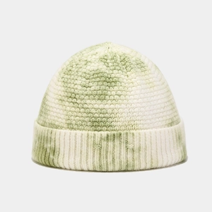 Detailed view of the green and white tie-dye knit texture on a trendy skullcap