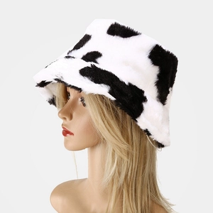 Close-up of plush cow print bucket hat showing soft faux fur texture and warm thick material