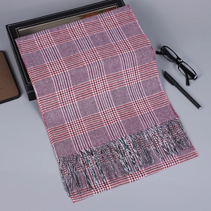 Détail d'une écharpe à carreaux en violet, blanc et rouge avec de douces franges aux bords