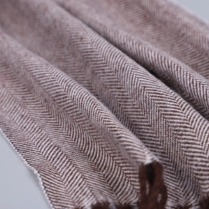 Détail macro du tissage à chevrons et des franges d'une écharpe d'hiver chaude et douce