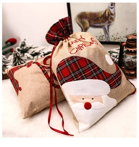 Detail of burlap Christmas gift bags with Santa and reindeer on white faux fur
