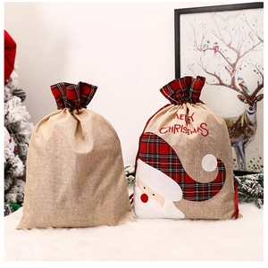 Detail of Christmas burlap drawstring bags with Merry Christmas embroidery and plaid trim