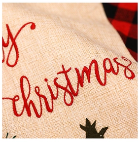 Detailed view of Merry Christmas embroidery on beige linen fabric for rustic holiday table mats