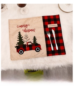 Christmas placemat detail with red truck and tree print on burlap fabric with cutlery holder