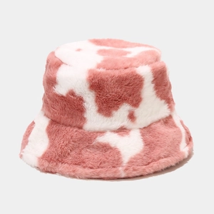 Close-up of soft plush texture on pink and white cow print faux fur bucket hat
