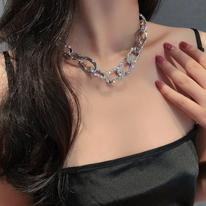 Collier ras de cou mode en chaîne argentée avec strass et maillons géométriques sur un mannequin
