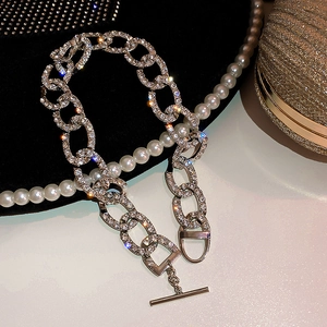 Vue macro des maillons double C sertis de cristaux et fermoir à bascule sur collier argent