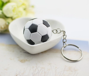 Porte-clés mini ballon de foot noir et blanc présenté dans un bol blanc en forme de cœur