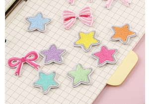 Detail showing colorful star and bow embroidered iron-on patches in pastel macaron shades