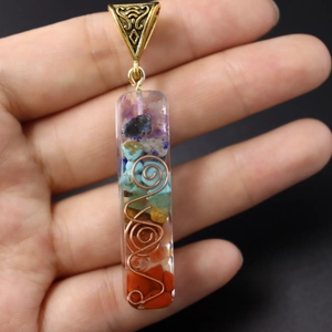 Macro view of handmade 7 chakras resin pendant with copper spiral and colorful stones