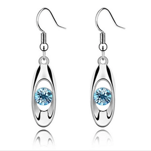 Detail of silver drop earrings with blue round crystals and long hollow pendant design
