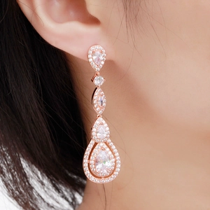 Close-up of rose gold drop earrings with AAA zirconia crystals on female model ear