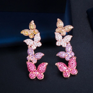 Detailed close-up of rose gold butterfly earrings with colorful pavé rhinestones