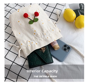 Detail shot showing internal capacity of canvas bucket bag with cherry embroidery