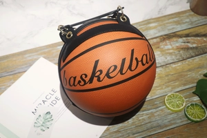 Detail of creative basketball-shaped crossbody bag with orange synthetic leather texture