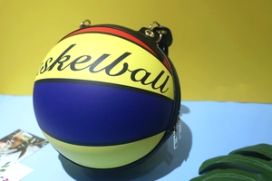 Detail showing the textured surface and colorful basketball graffiti art on the chain bag