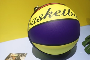 Detail of yellow and purple basketball bag showing PU leather texture and metal hooks