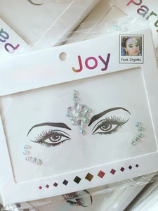 Close-up of rainbow crystal face stickers with intricate facets for party makeup